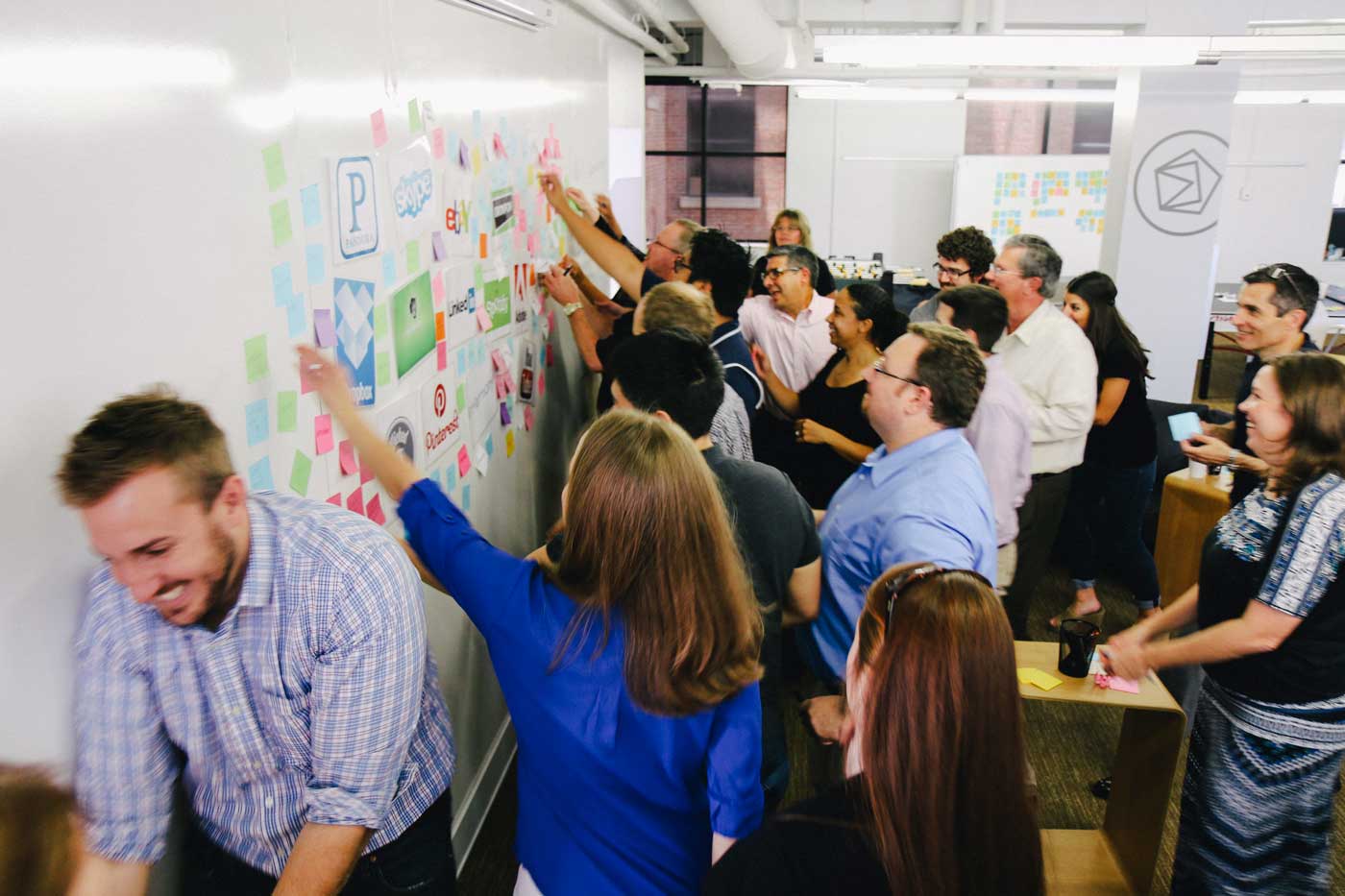 Workshop participants rush to the whiteboard for an ideation exercise.