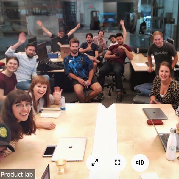 The whole creative team sits around a table for a Zoom call.