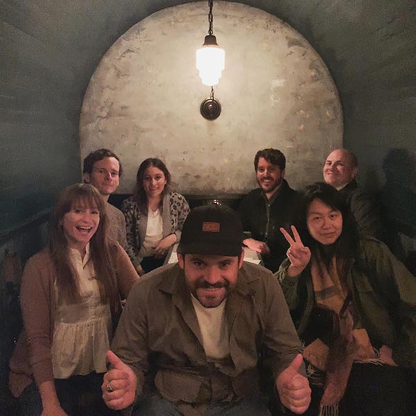 Teammates get together for some drinks in an art deco alcove.