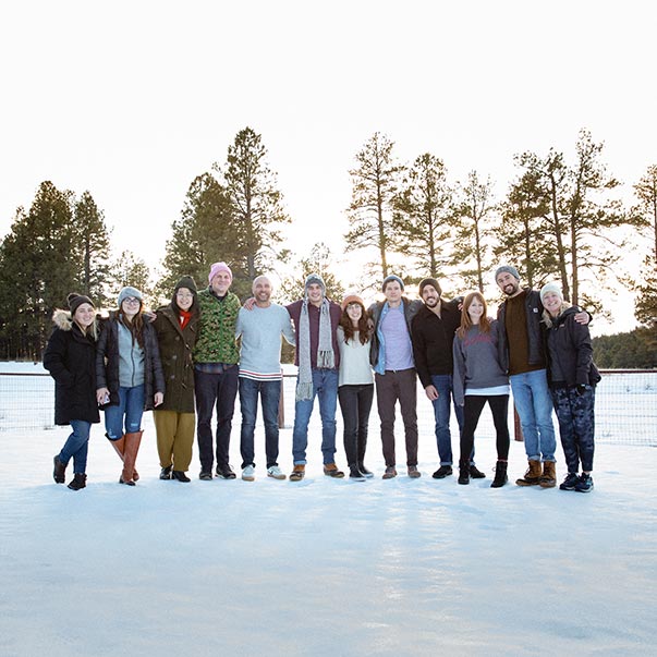 The designers stand in a snowy field for a team picture.