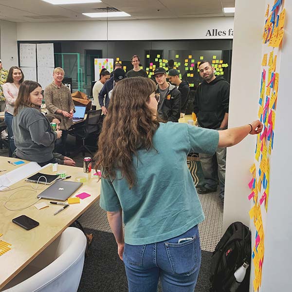 A young designer shares her brainstorming concepts to a room full of colleagues.