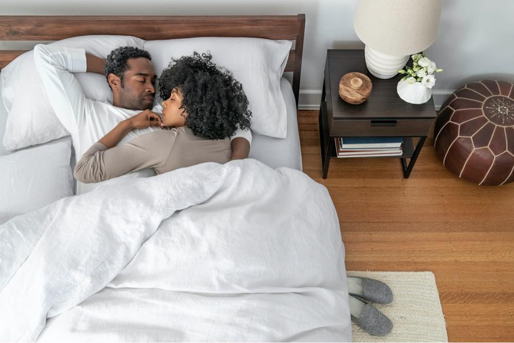 An overhead shot of a couple sleeping in bed.